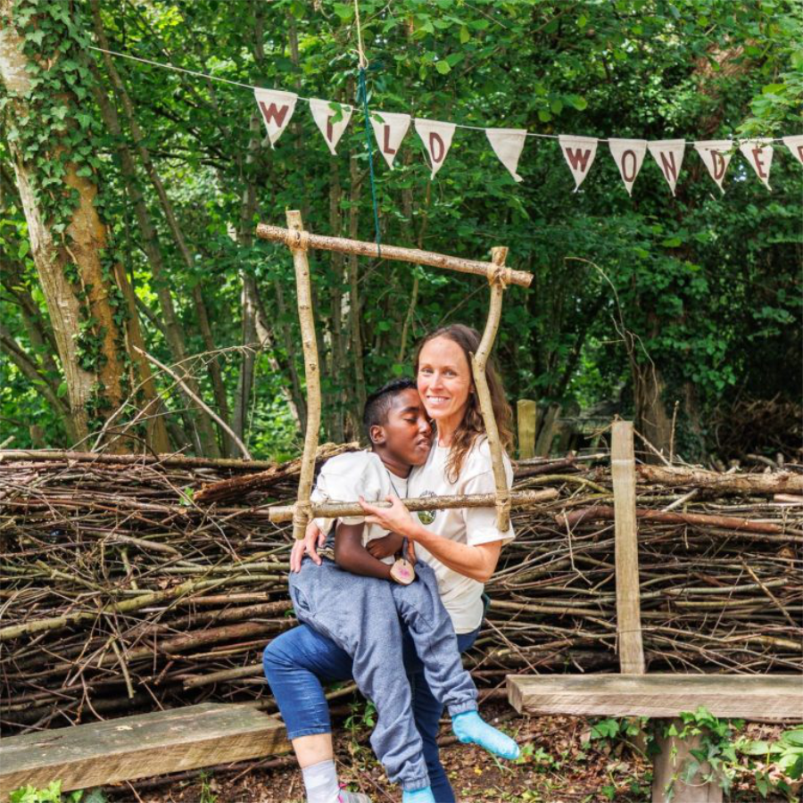 A mother and son playing in the woods