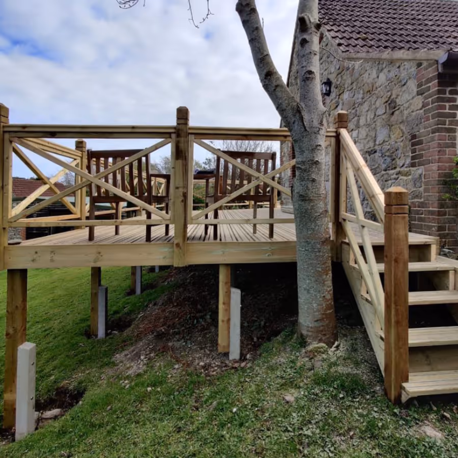 A new wooden deck in the garden of an old stone house