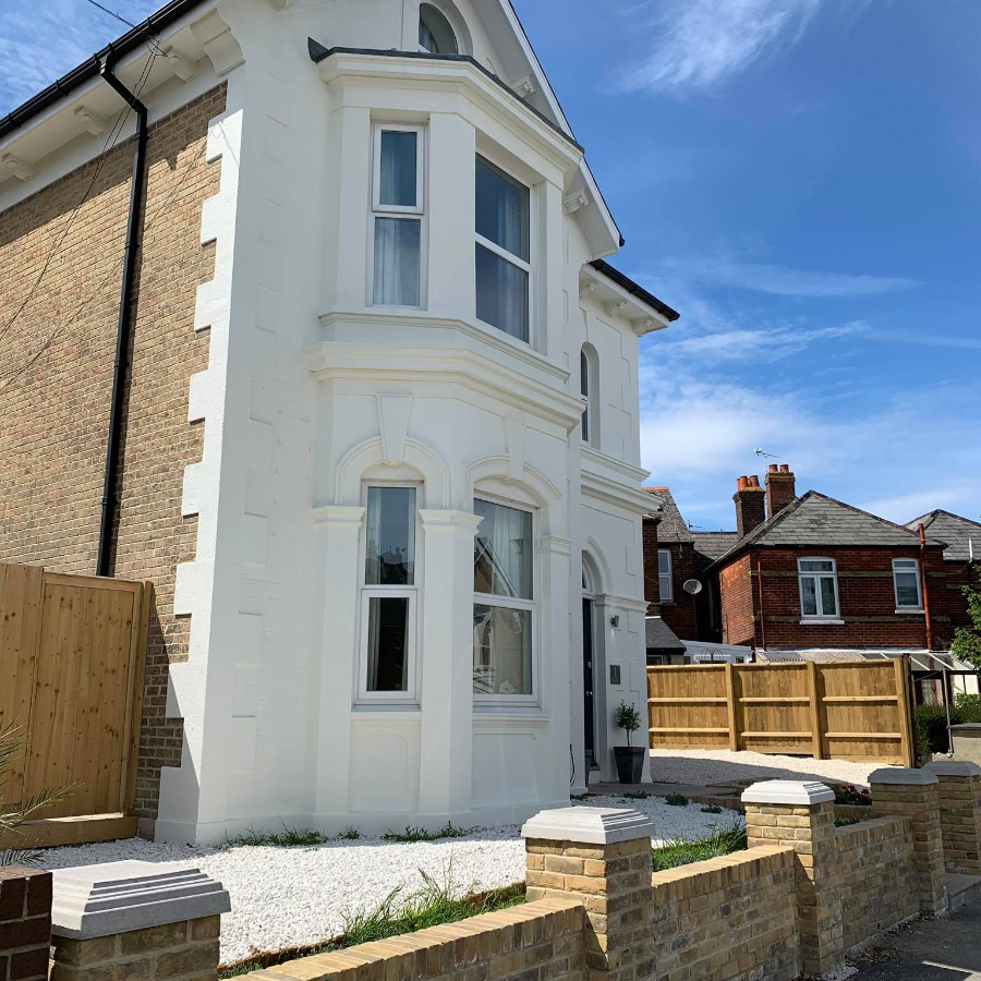 A brick house with a painted front facade