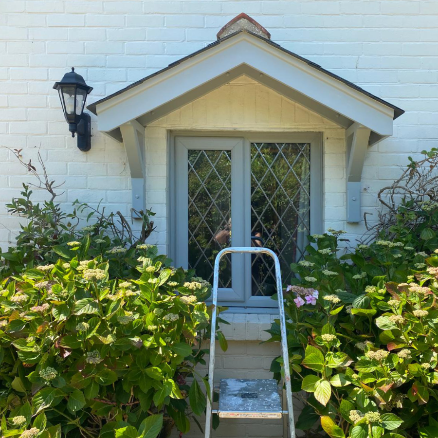A ladder stood in front of a newly painted window frame