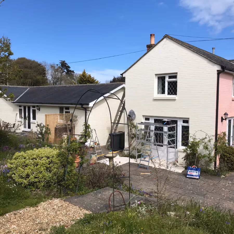 A pink house being painted cream