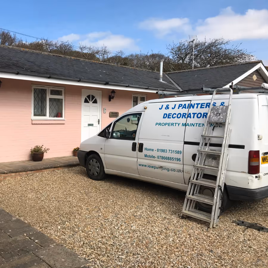 A decorators van parked outside a pink house