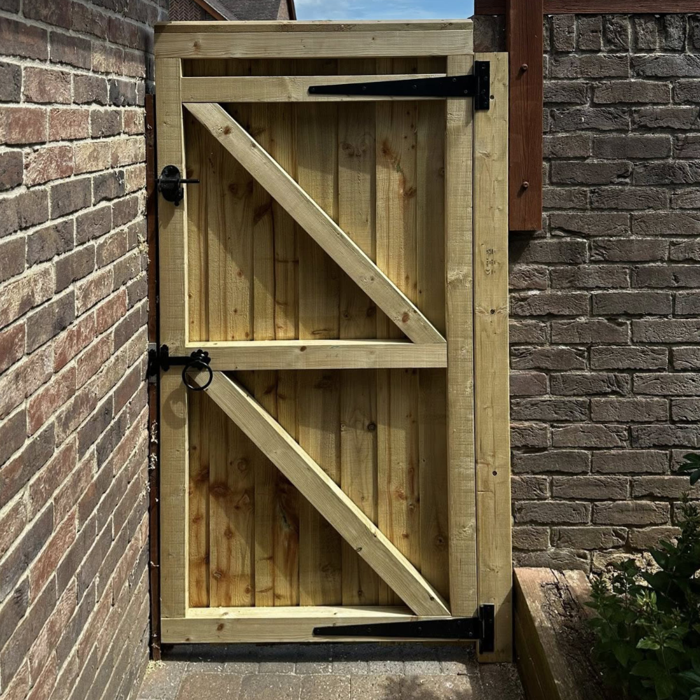 A wooden gate within a brick wall