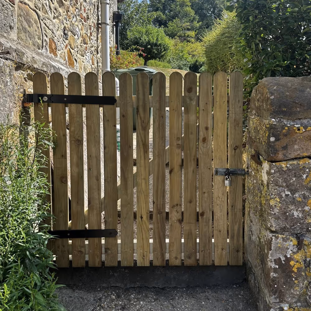 A wooden gate within an old stone wall