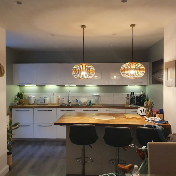 A modern white kitchen with pendant lighting.