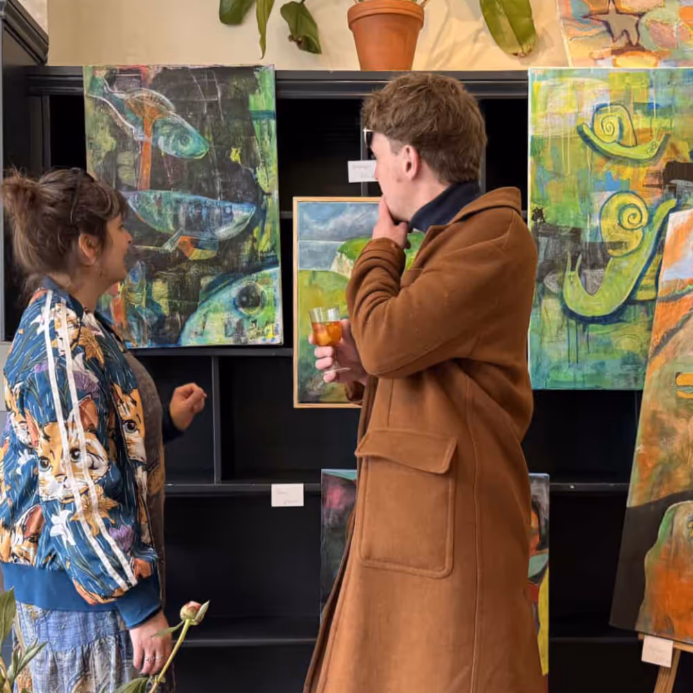 Two people admiring paintings in an art gallery.