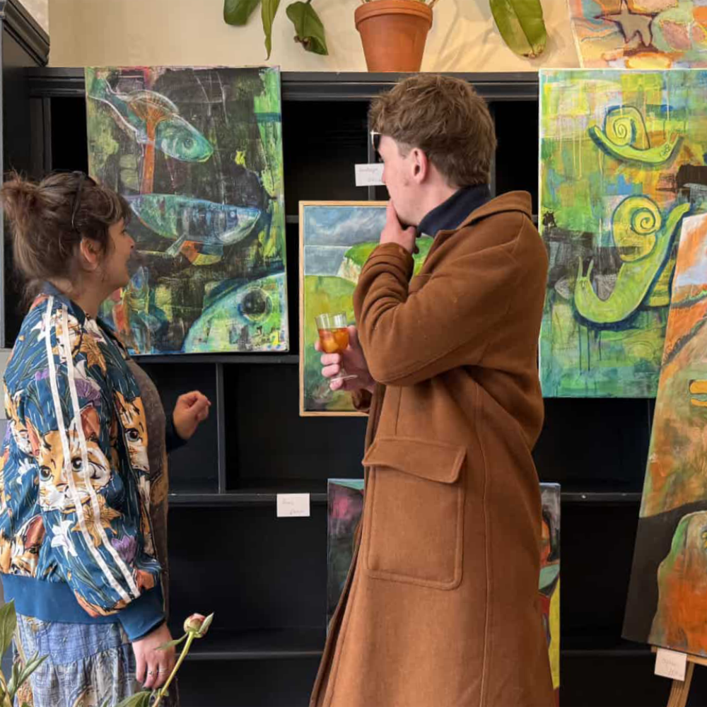 Two people admiring paintings in an art gallery.