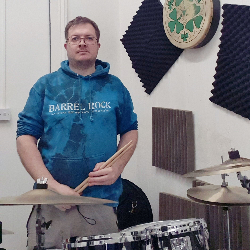 A drummer sitting at his kit.