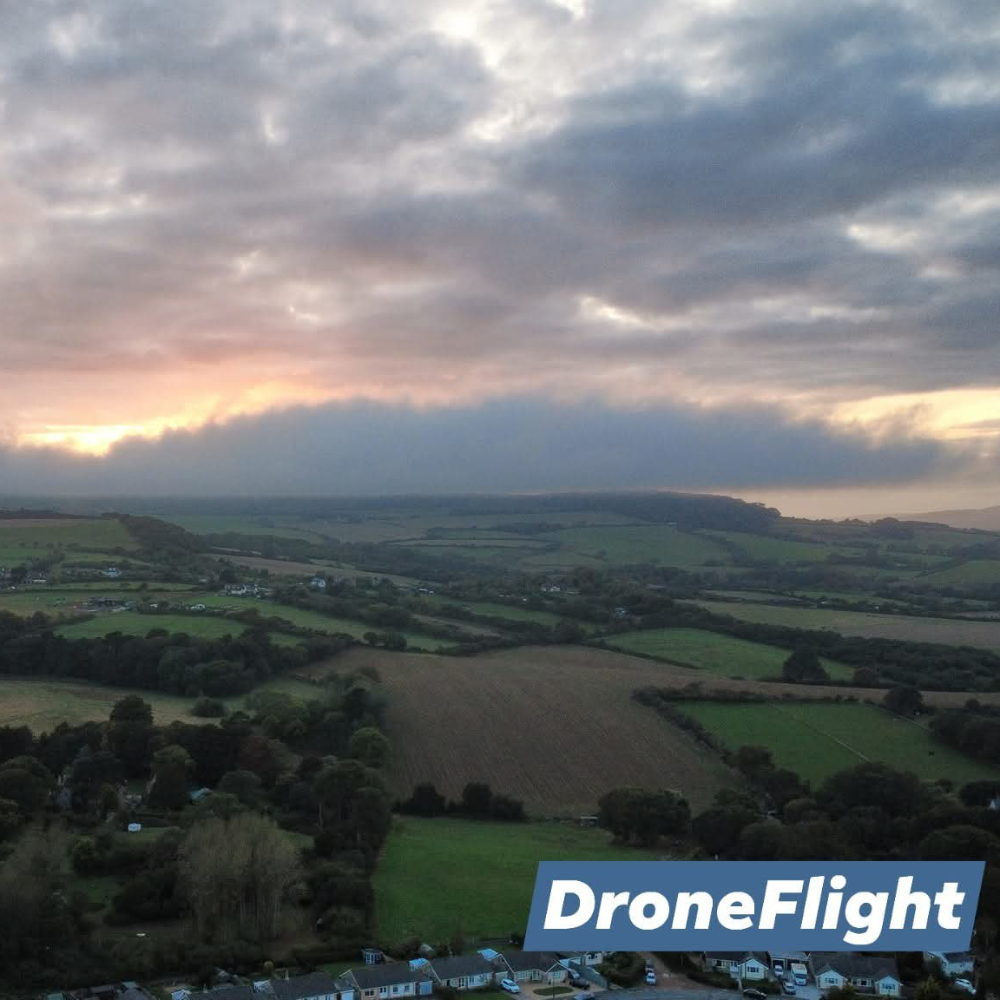 An aerial shot of a sunrise over rolling fields.