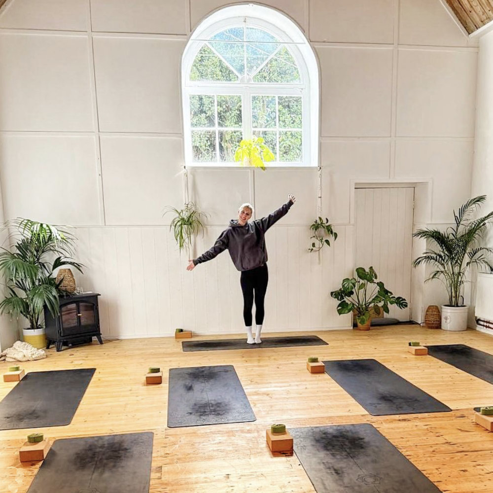 A woman standing in a pilates studio.