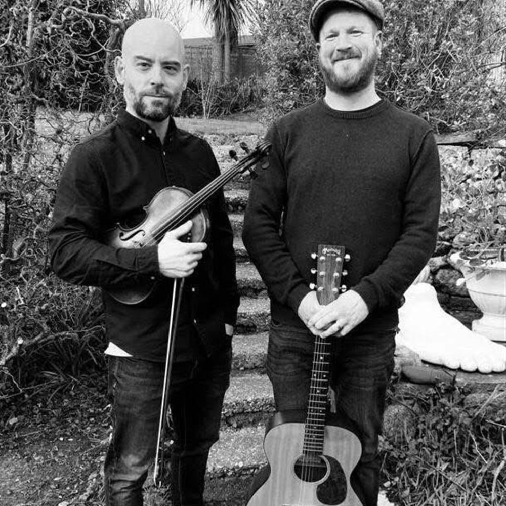 Two musicians holding their guitars.