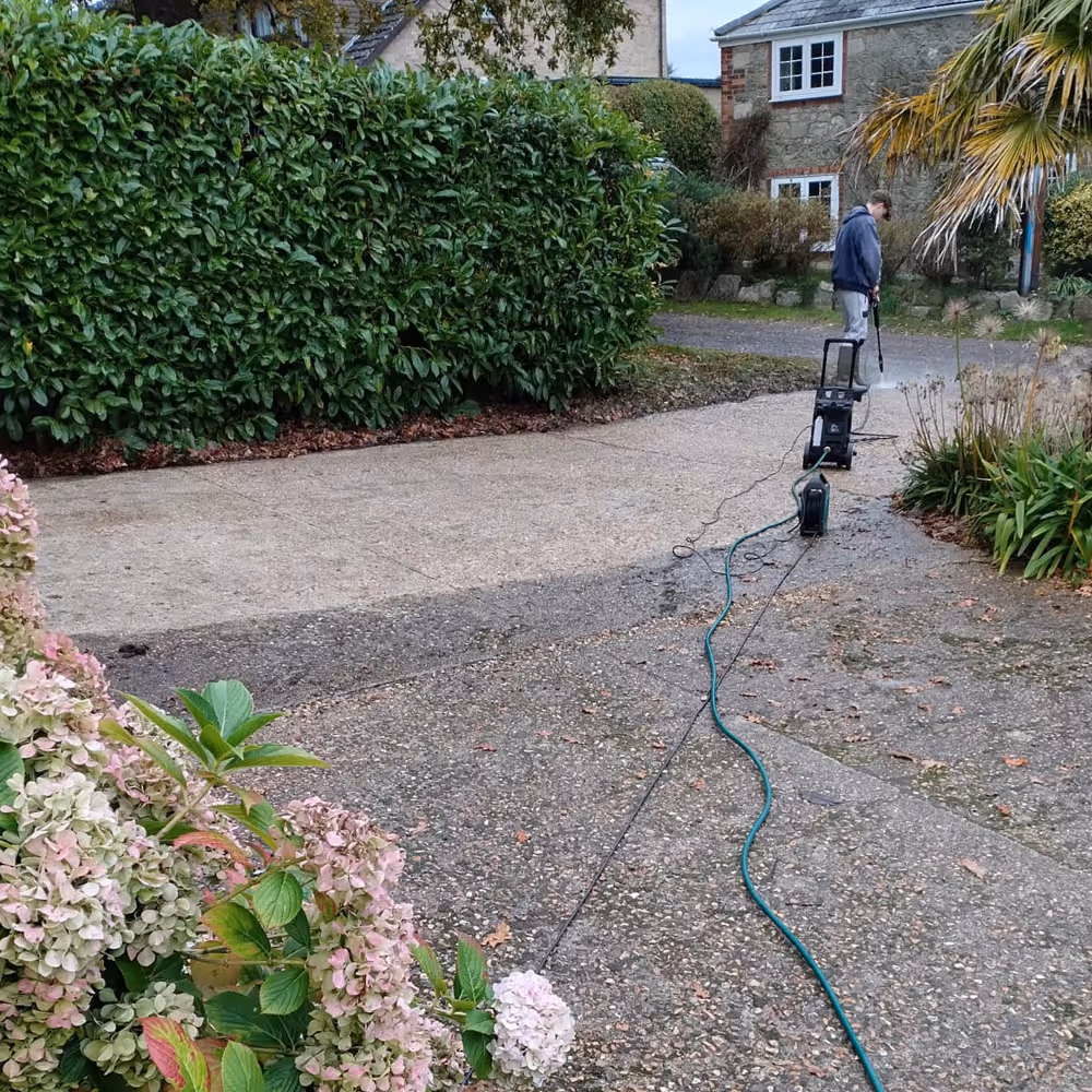 Someone jet washing a driveway.
