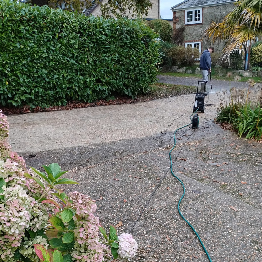 Someone jet washing a driveway.