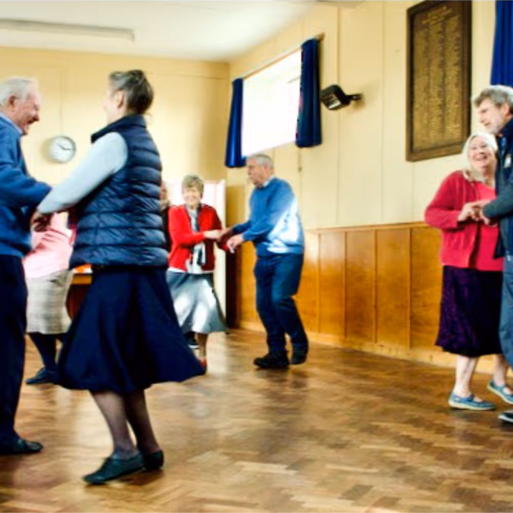 People dancing in a village hall.
