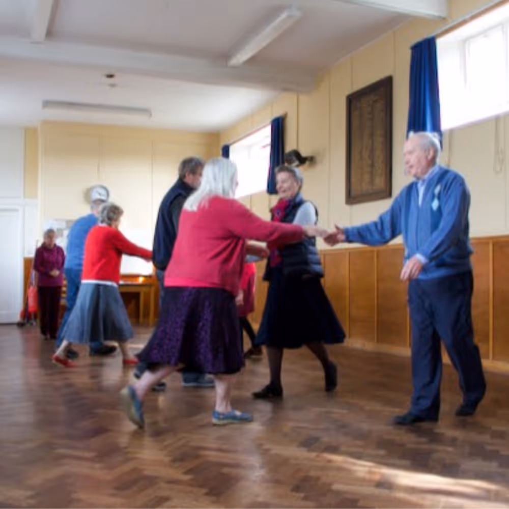 People dancing in a village hall.