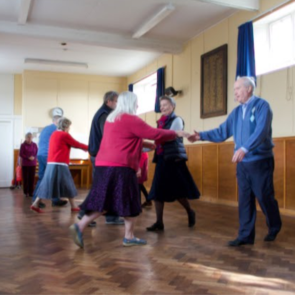 People dancing in a village hall.