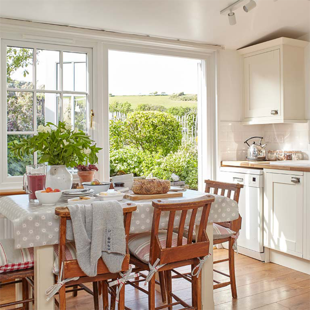 A country style kitchen with a door opening out onto a garden.