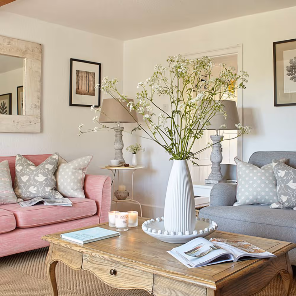 A pretty country livng room with a pink sofa.
