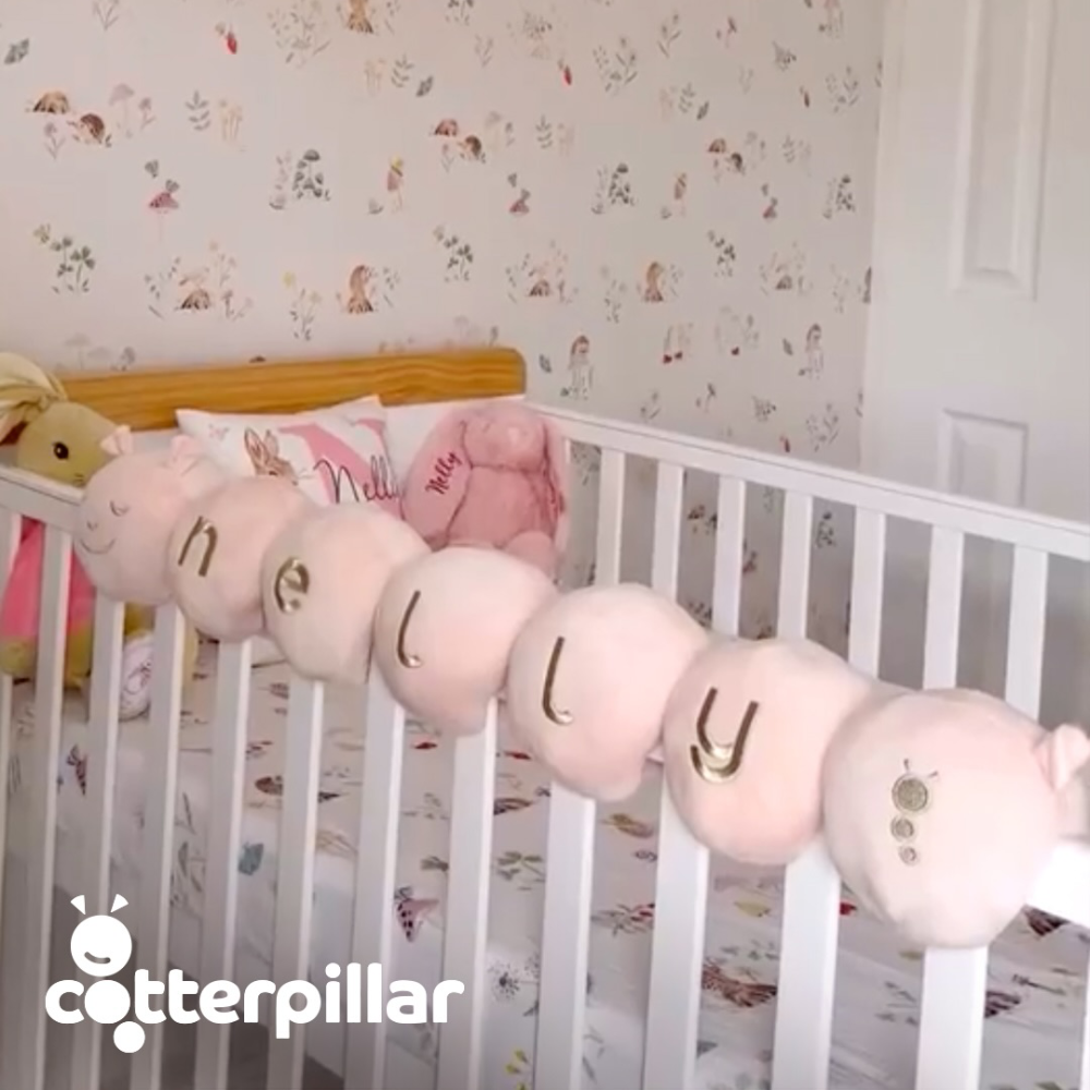 A soft velvet personalised caterpillar for a baby's cot