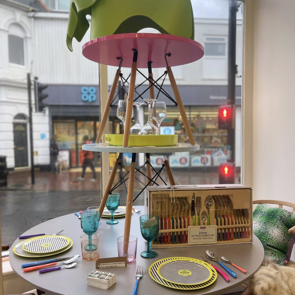 A stack of chairs upon a dining table in a shop window
