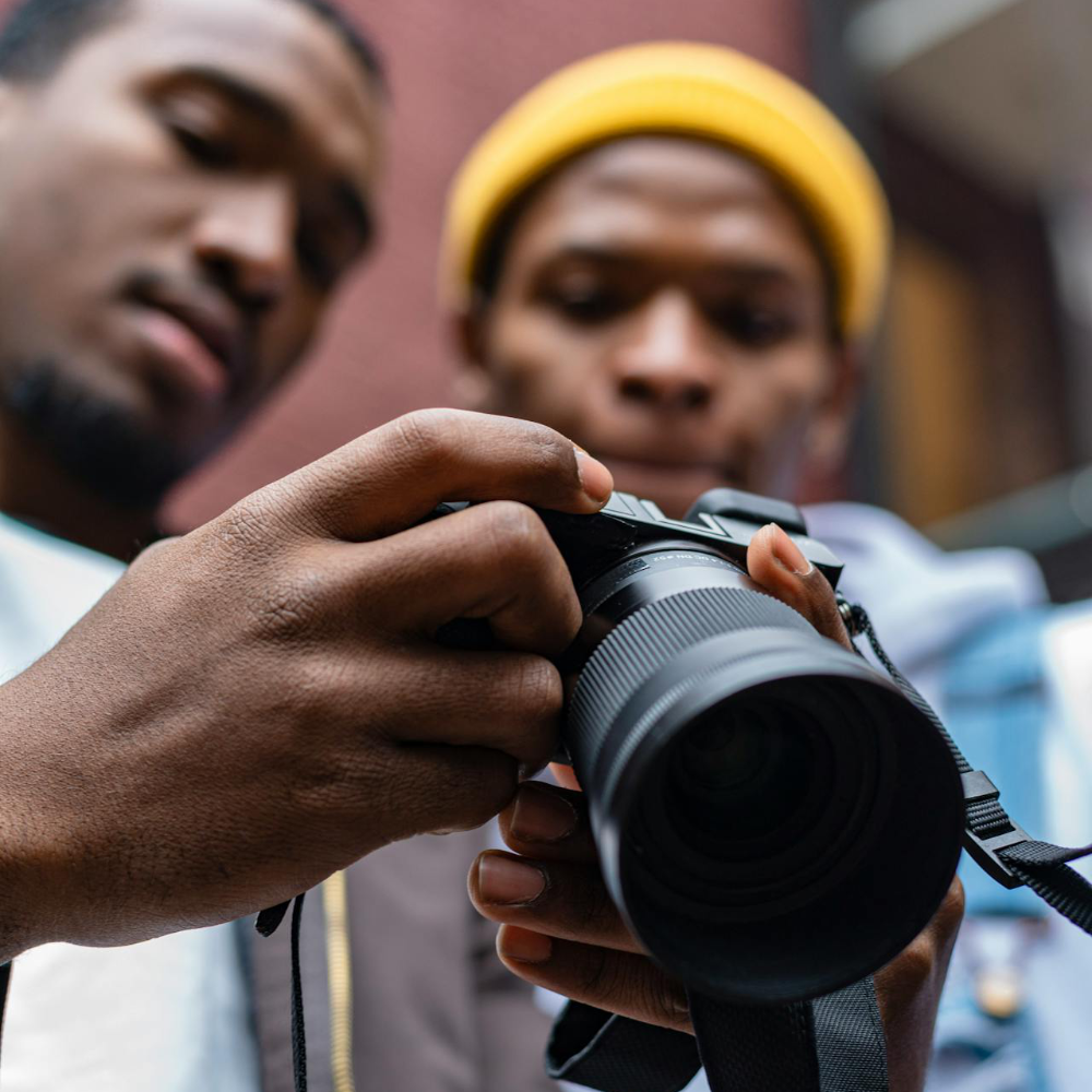 Two men viewing the backscreen of an SLR camera