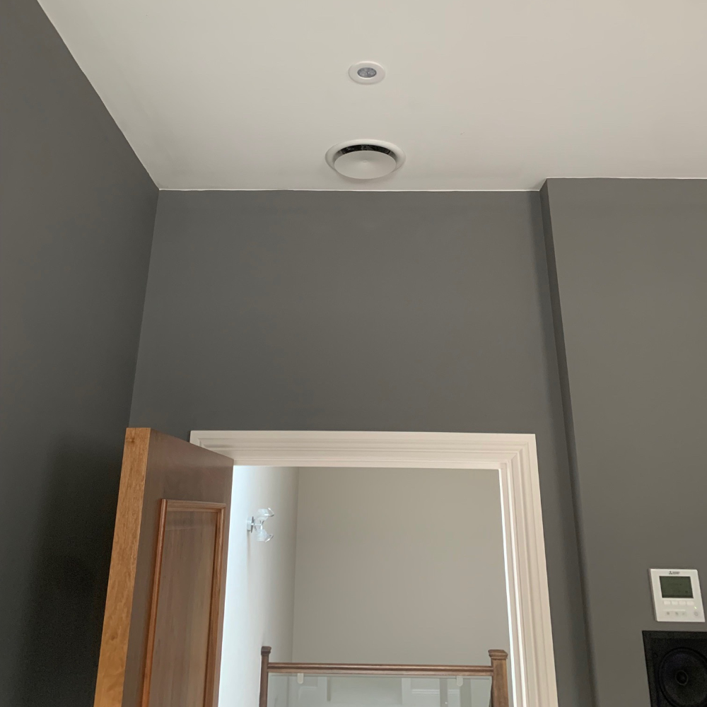 A small air conditioning unit ceiling mounted above a doorway