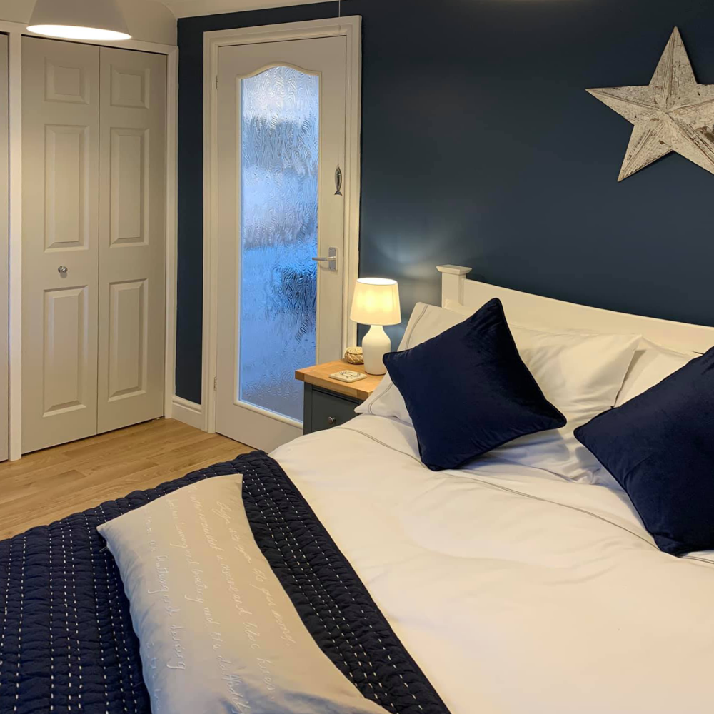 A coastal themed bedroom in blue and white.