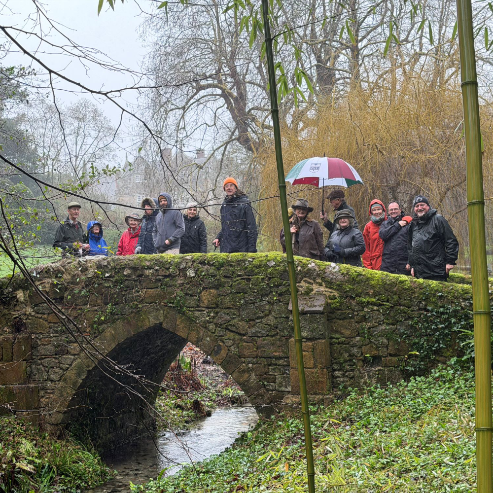 A group of people walking across a small stone bridge