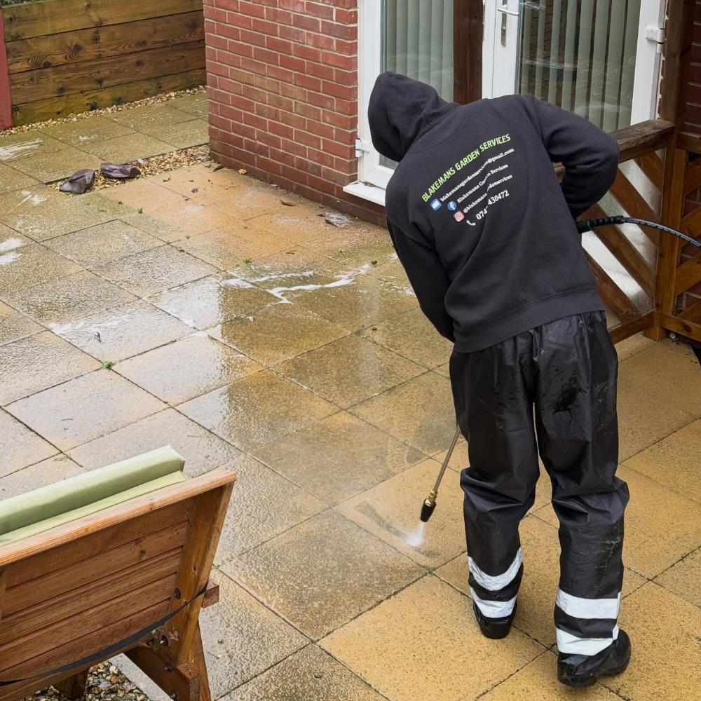 A man jet washing a patio