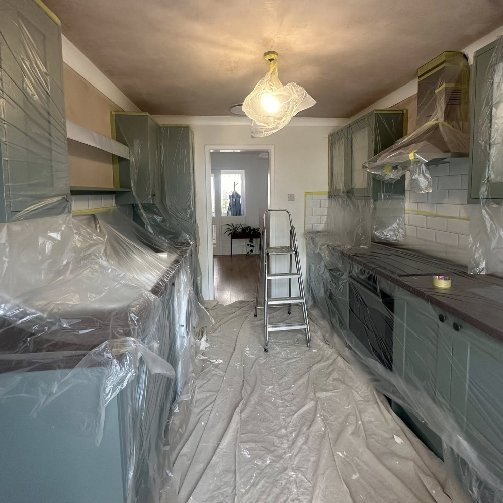 Kitchen cupboards protected with plastic sheet before being decorated.