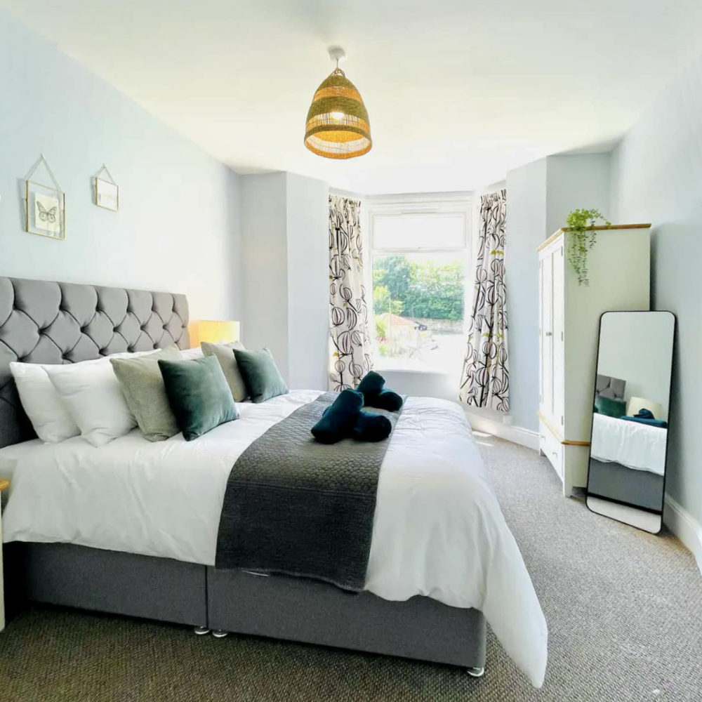 A bright and airy bedroom with soft blue walls.