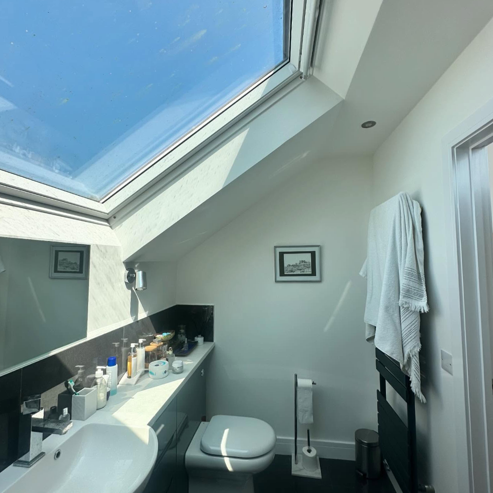 An ensuite shower room with a large skylight set into an angled.