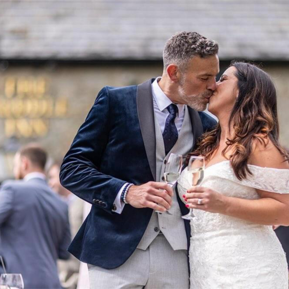 A newly married couple enjoying a kiss at the reception.