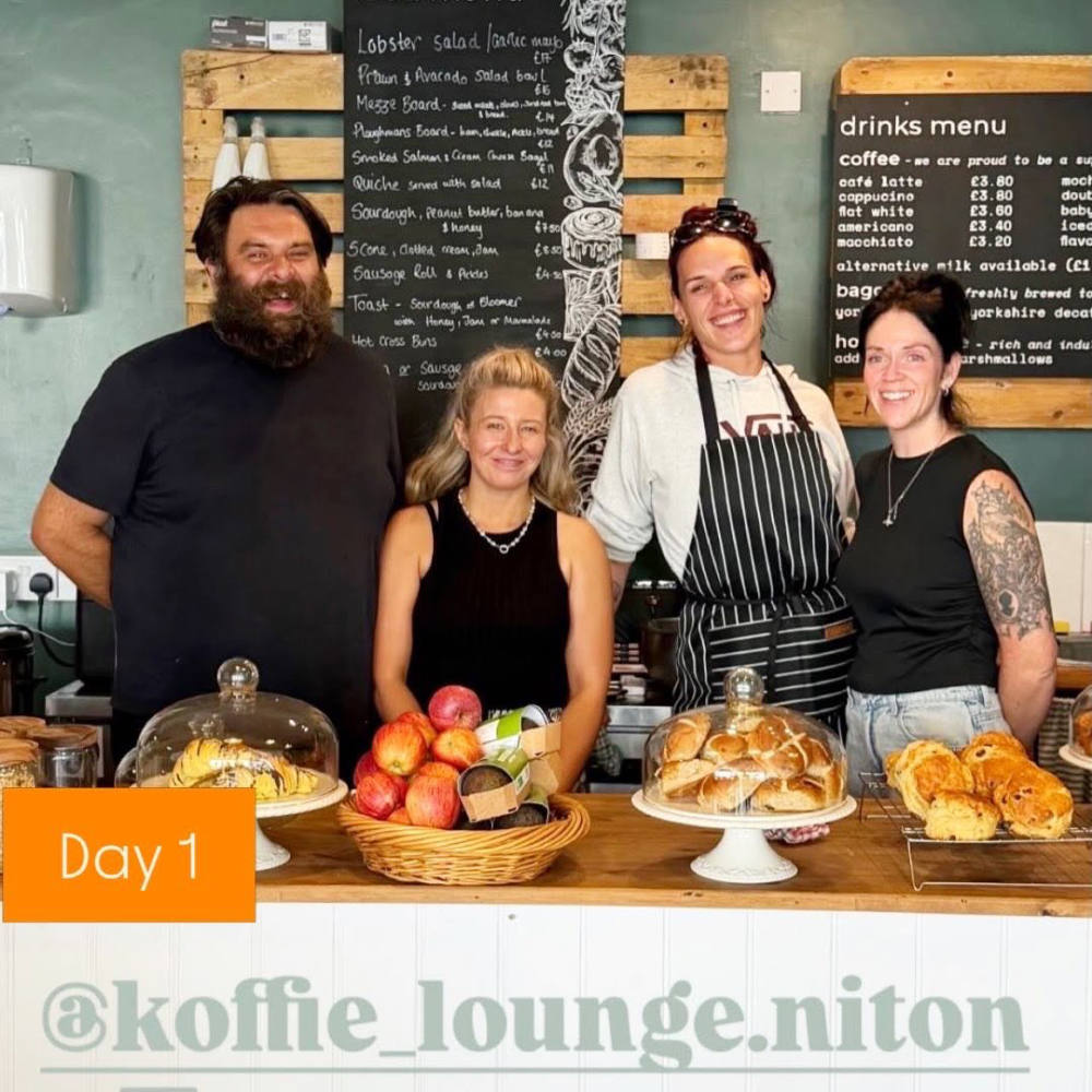The team of a cafe stood behind the serving counter.