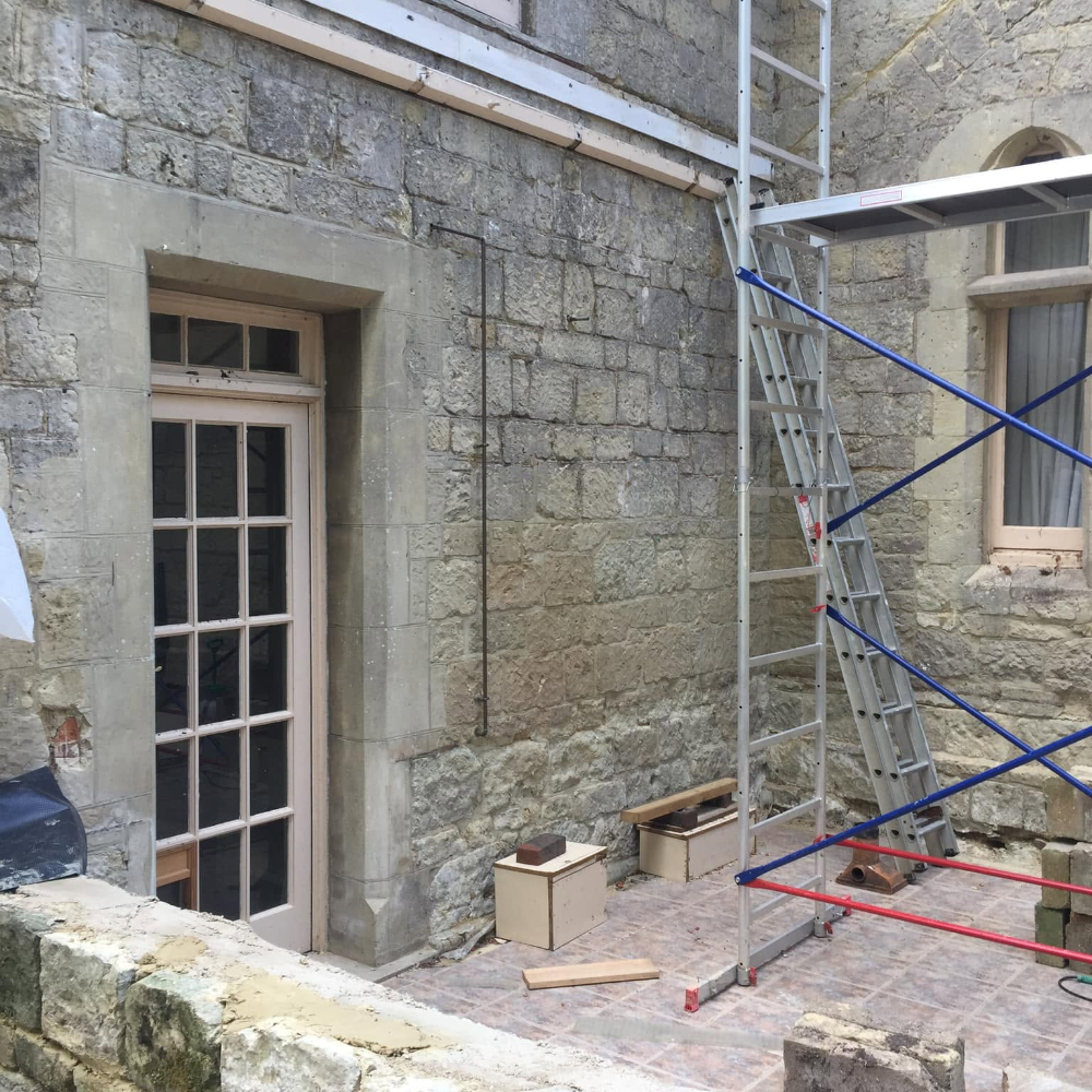 A builder working on a stone house.