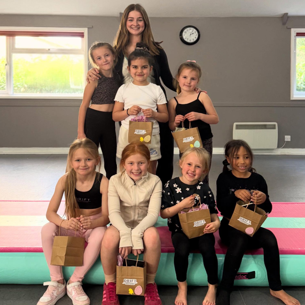 A teacher and her dance students in a group.