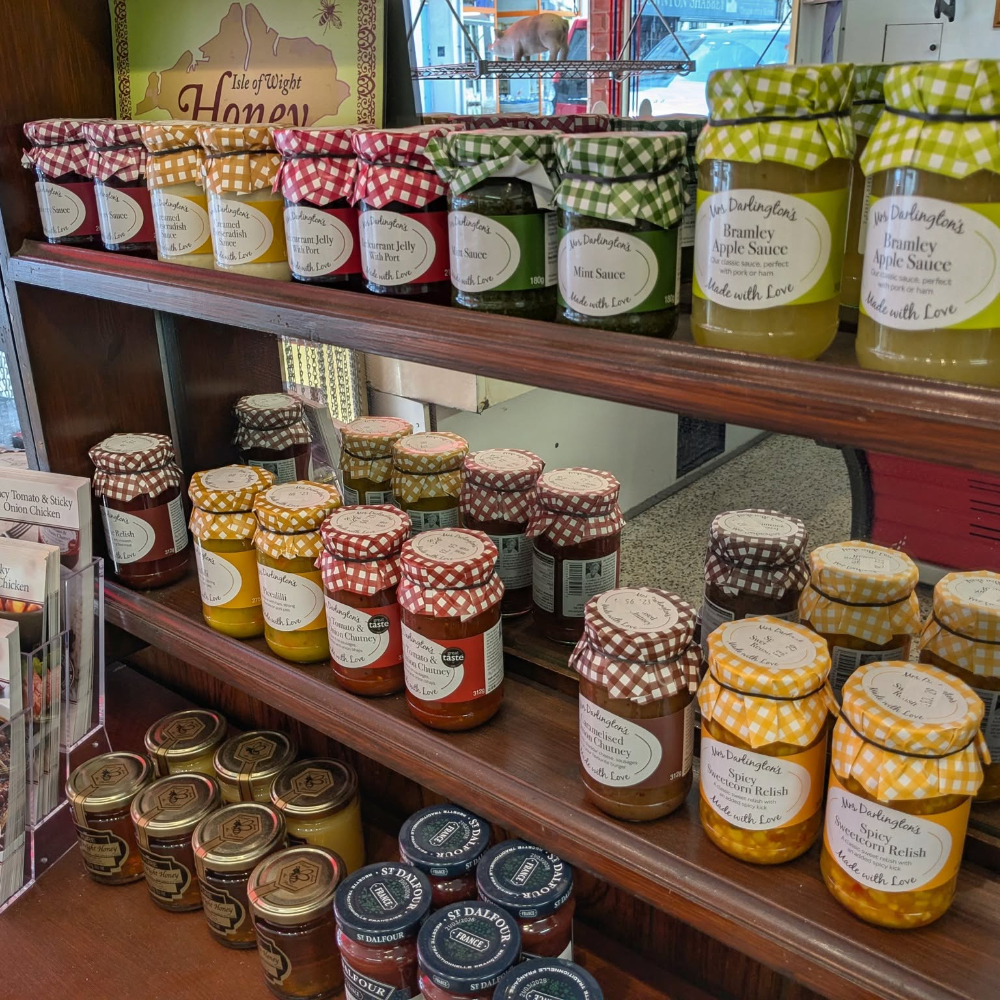 Jars of preserves on a shelf in a shop.