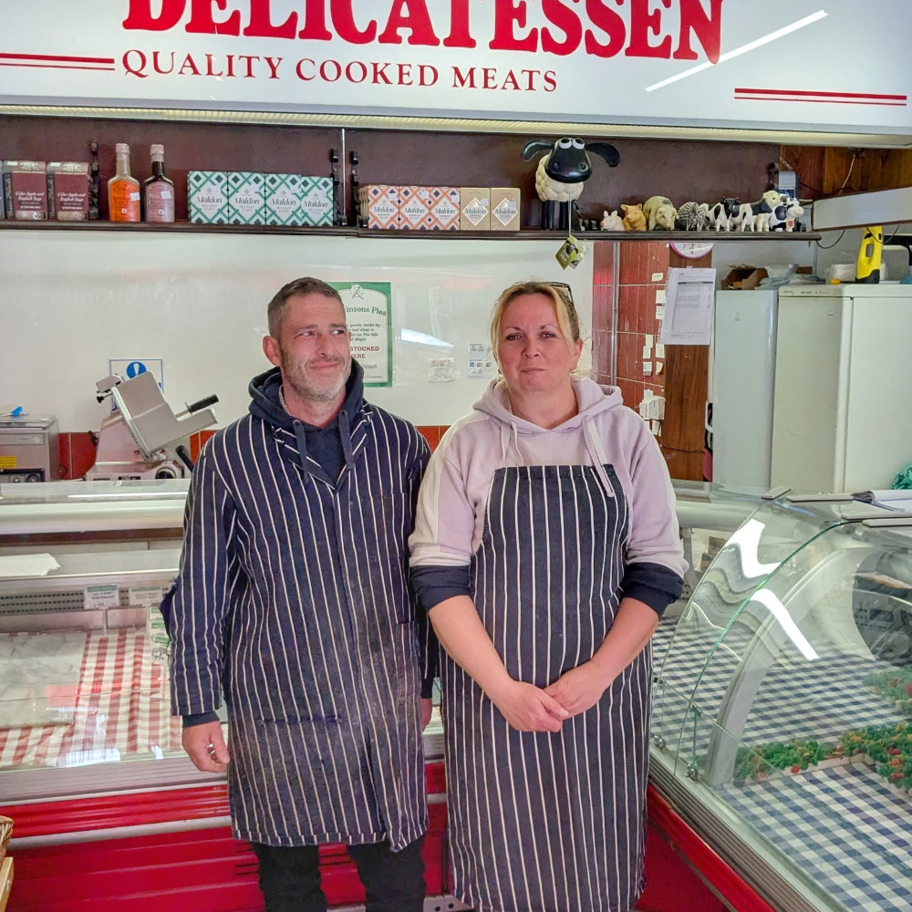 A man and woman in a butchers shop.