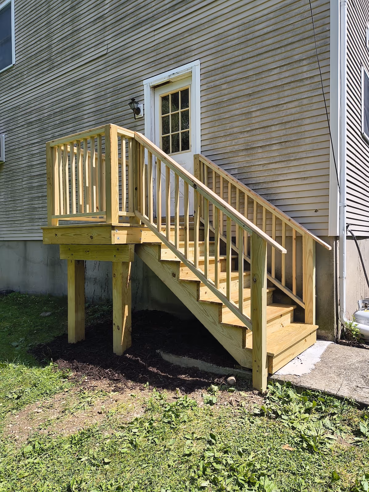 Newly constructed wooden egress staircase with railings.