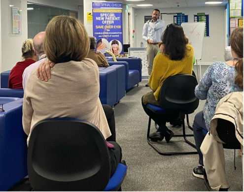 A group of people sitting in chairs in a roomAI-generated content may be incorrect.