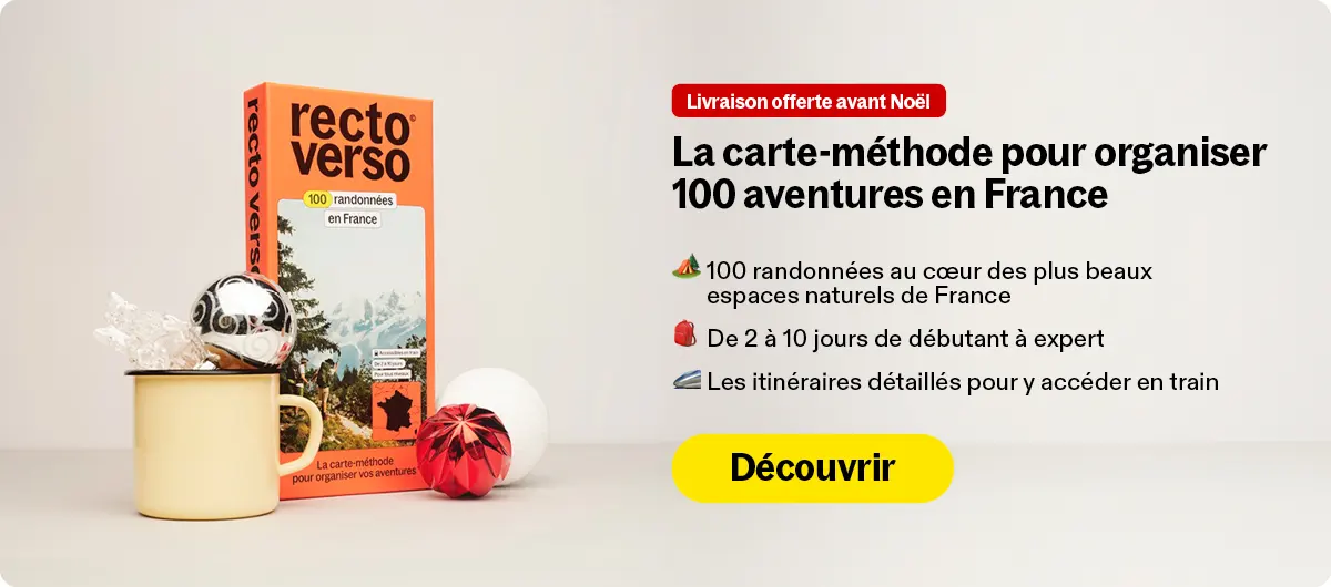 Une boîte orange de la carte-méthode Recto Verso posée à côté d'une tasse crème contenant des boules de décoration de Noël, avec texte promotionnel pour organiser 100 aventures en France et un bouton jaune 'Découvrir'.