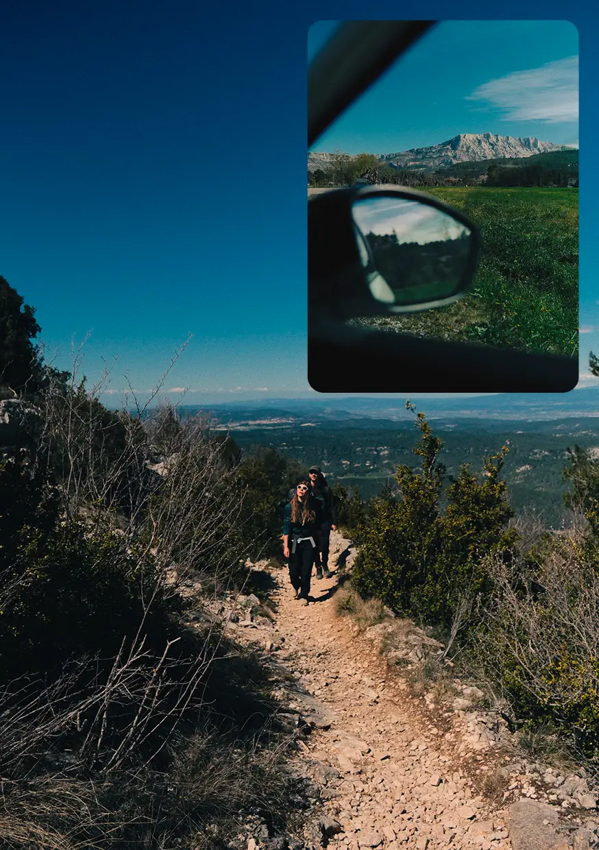 Randonneuse avec un sac à dos et raquettes sur l'épaule, regardant un paysage montagneux enneigé au coucher du soleil.