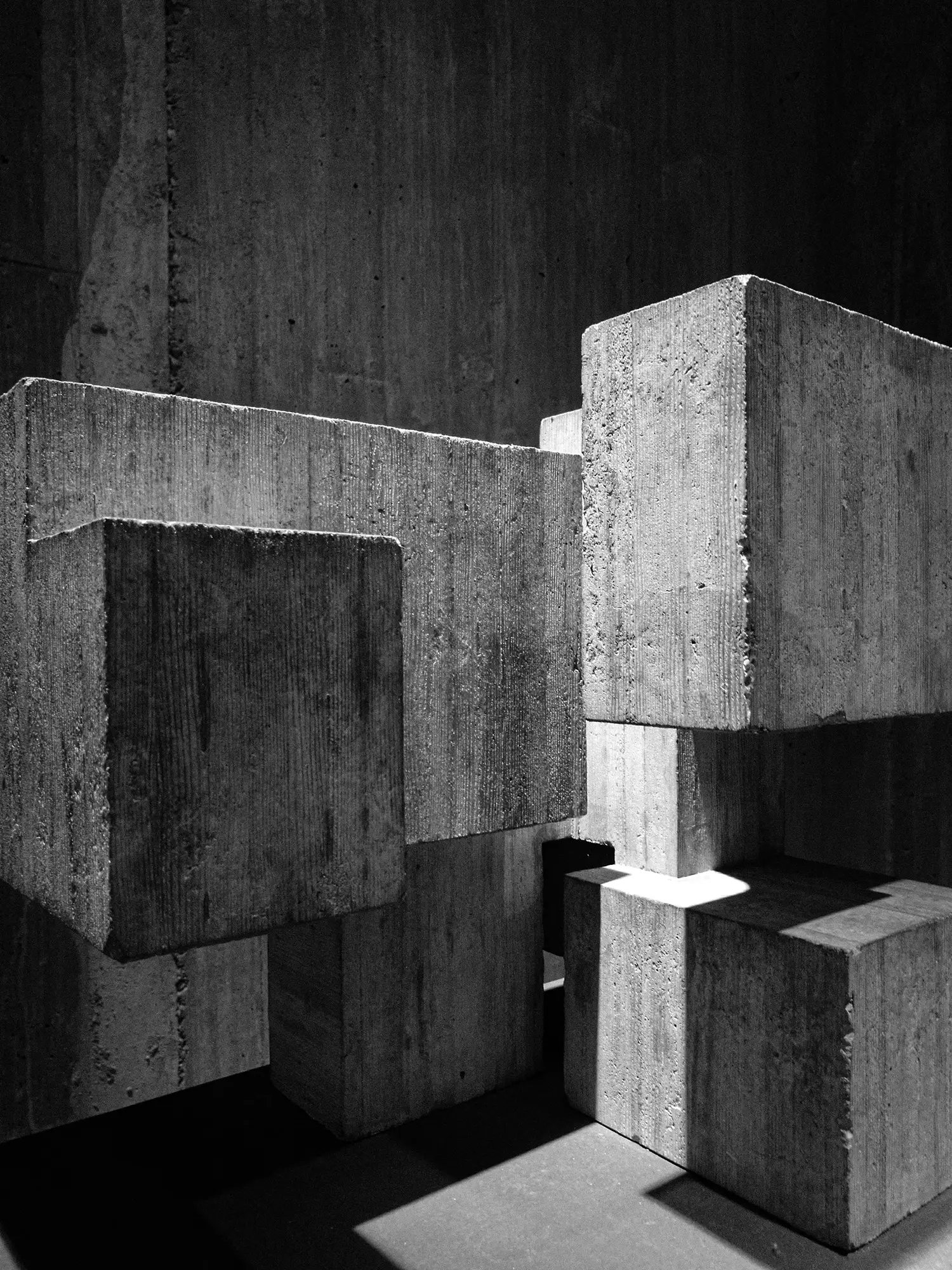 Interlocking modular concrete blocks in light and shadow, evoking composable architecture, black and white
