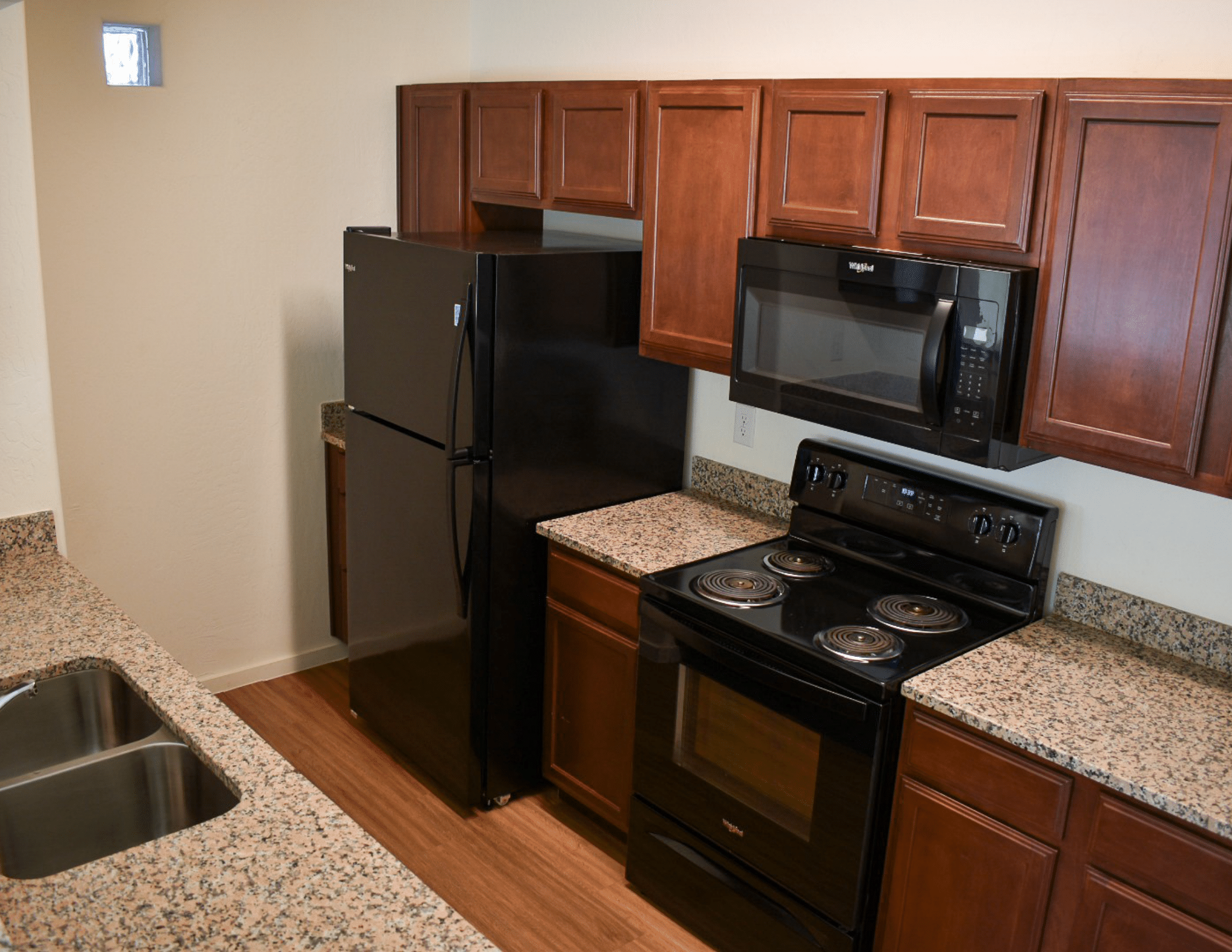 kitchen with black appliances and brown wooden cabinetry 