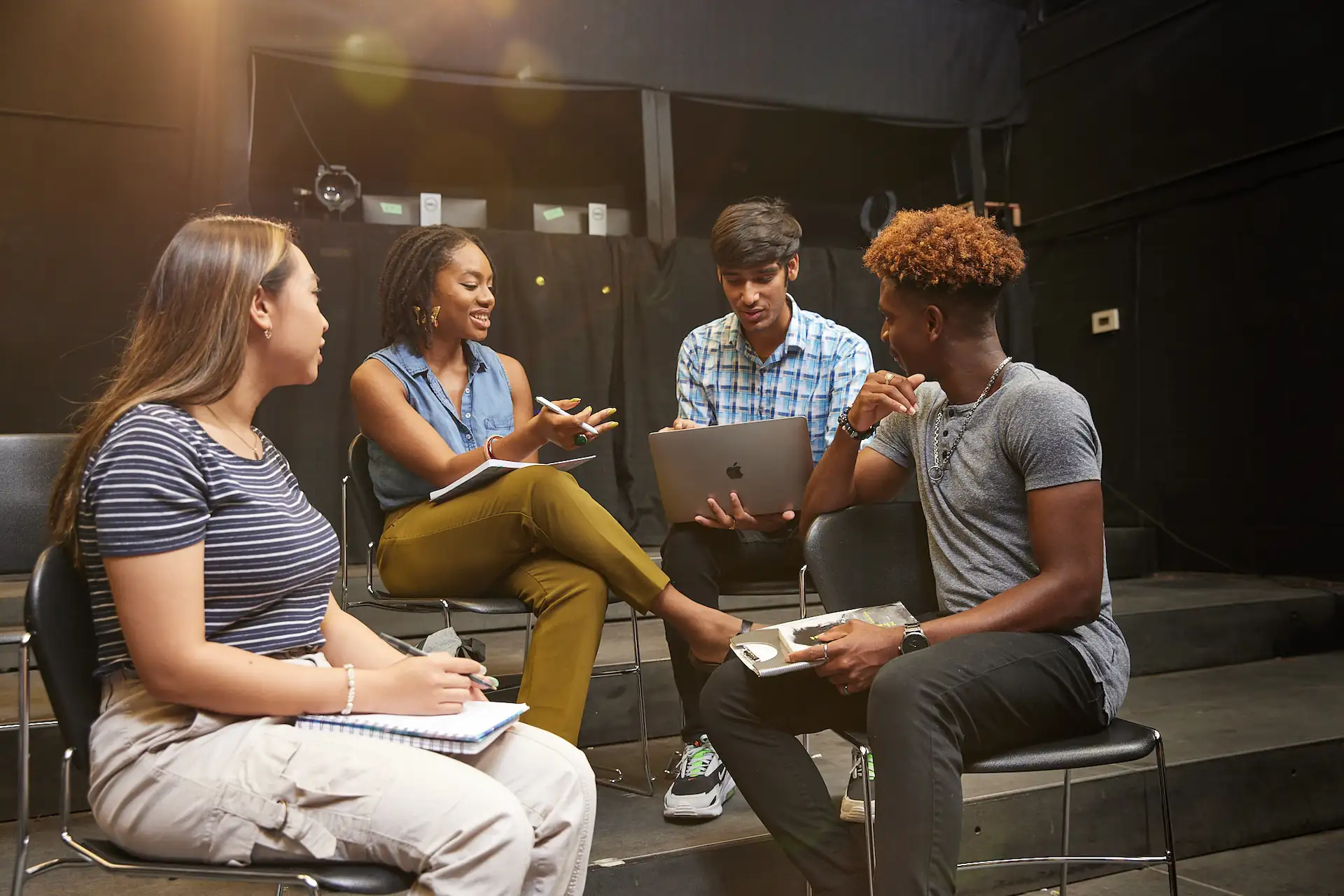 Students in a media setting using a laptop to access software