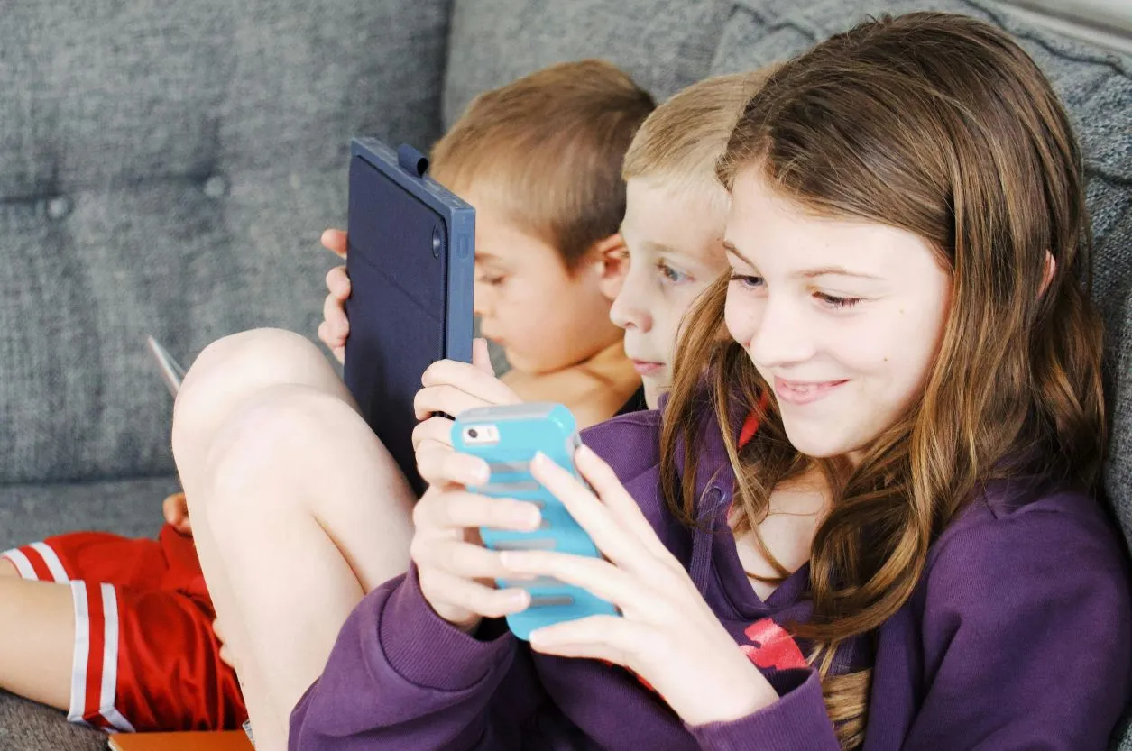 Three children watching their devices