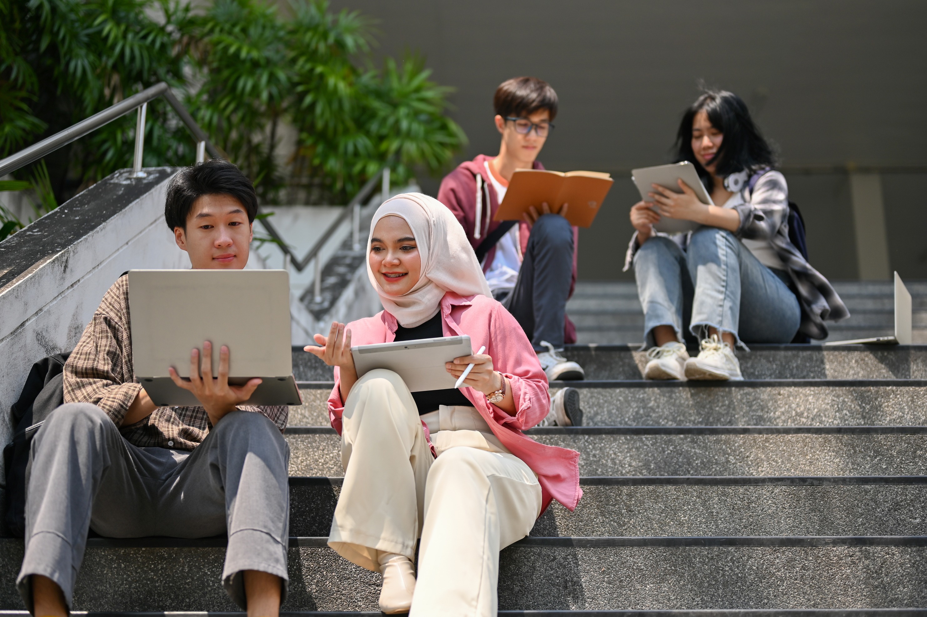 Students studying outside on their personal devices