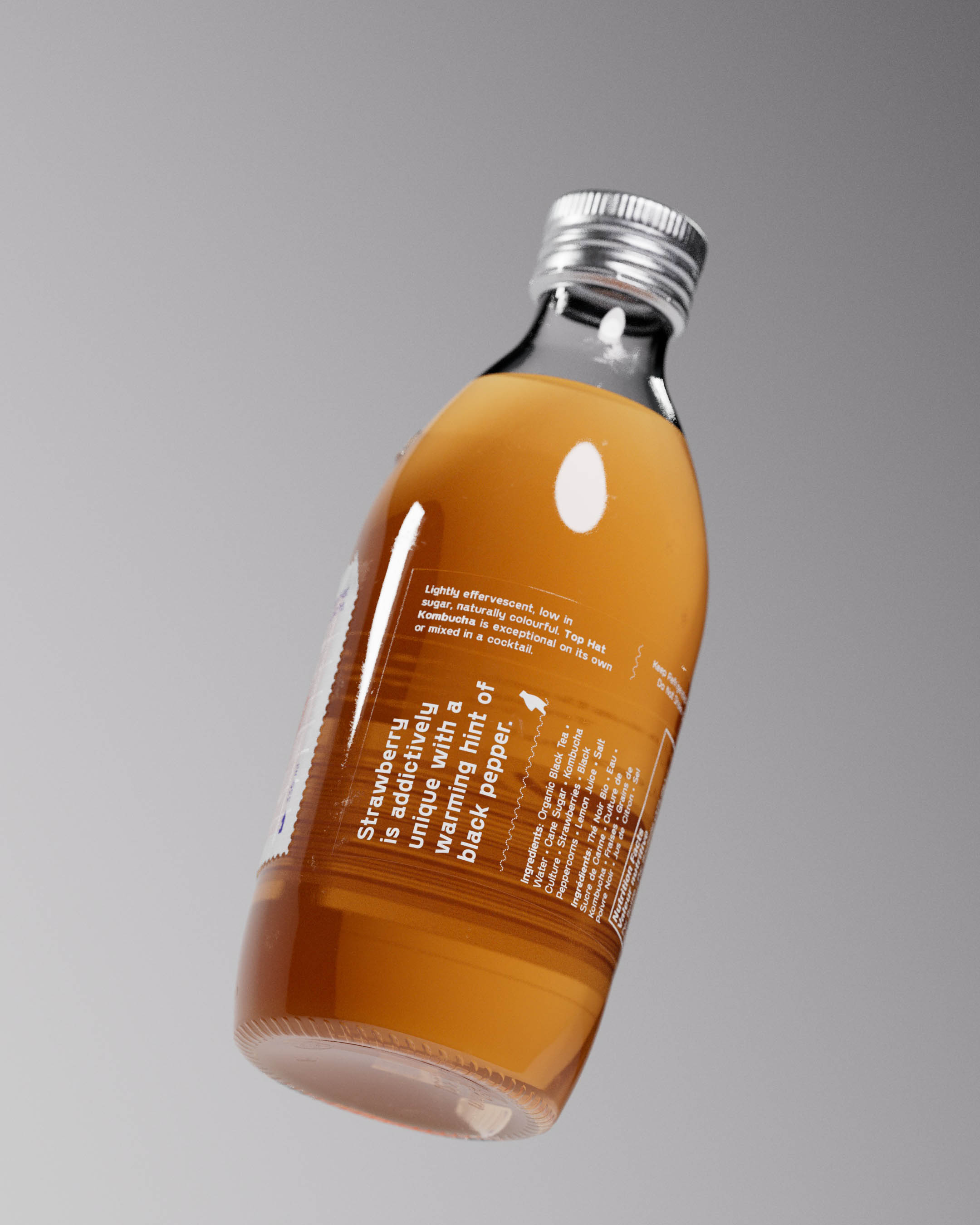 A Top Hat Kombucha bottle featuring the Strawberry Black Pepper flavor is shown up close, highlighting the secondary transparent label that wraps around the #packaging. This label offers ingredient details, nutritional facts, and social media handles, emphasizing a comprehensive brand story. The custom-molded bottle bears the iconic embossed hat logo, underscoring the premium kombucha quality. The primary label features abstract geometric art and spot Pantone colors, hinting at the unique flavor profile. The tactile Spot UV grid adds a sophisticated touch to the packaging, making it immediately recognizable on shelves. 