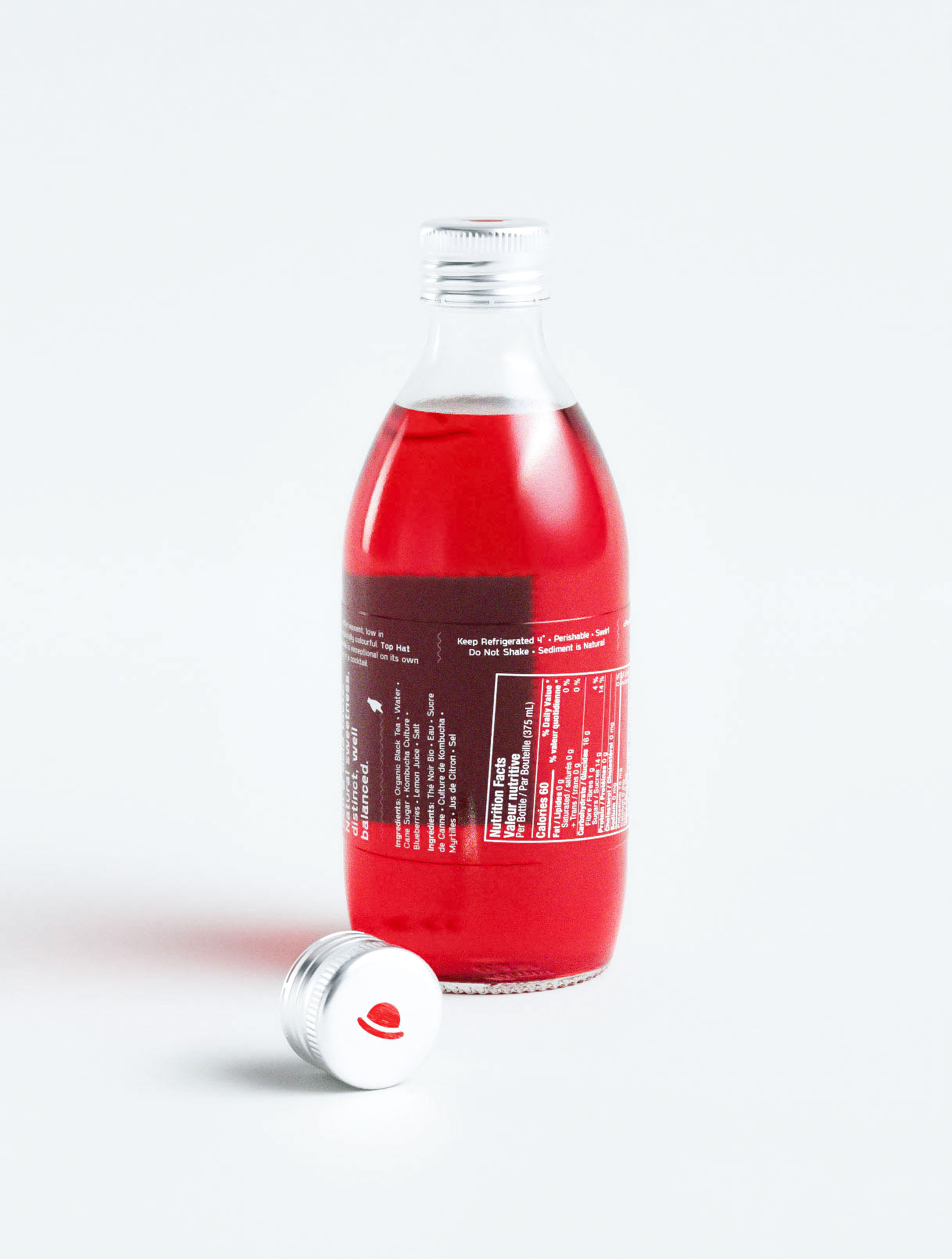 Contemporary packaging design studio work for red kombucha featuring dual-panel label system with comprehensive nutrition facts and ingredient transparency. Professional design agency portfolio showcasing strategic information architecture balancing regulatory compliance with brand messaging. Creative beverage packaging design demonstrating expertise in health food sector with bilingual typography treatment and sustainable glass bottle format for premium probiotic drink positioning.