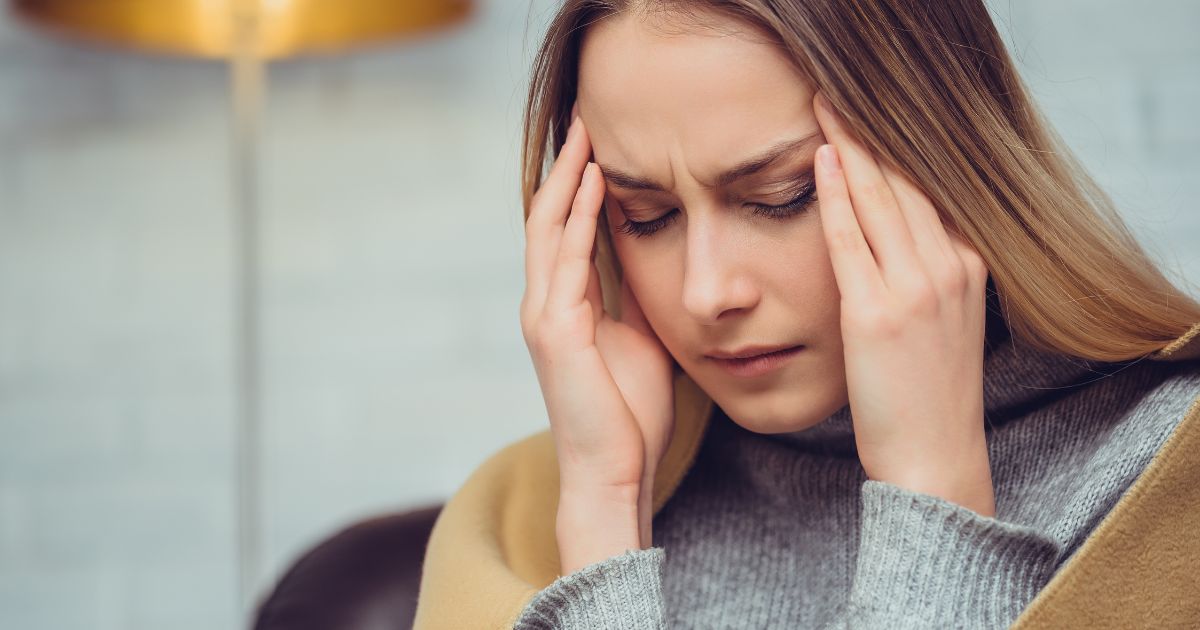 woman holding or temples experiencing headache or migraine